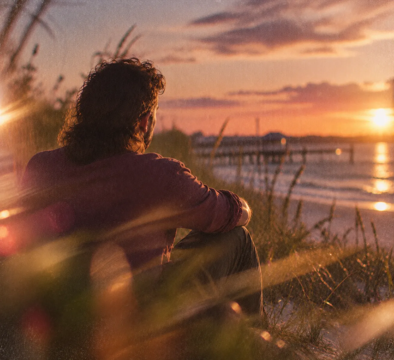 A man watching the sun set over the water